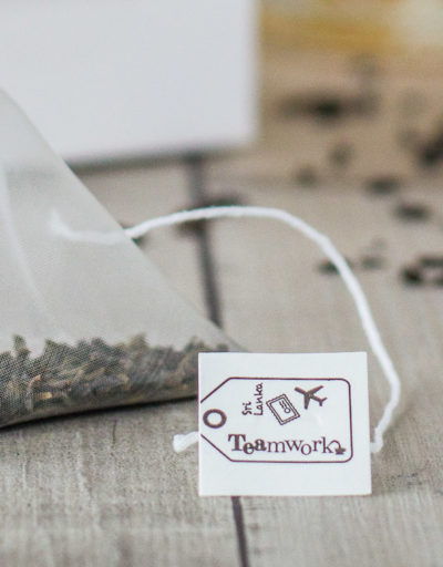 Hoe maak je een theezakje zo duurzaam mogelijk, zonder in te boeten op de kwaliteit van losse thee? Voor dat laatste heb je een piramidezakje nodig: daarin hebben de grote, met de hand geplukte theeblaadjes van TEAmwork Tea de ruimte om te wellen. Ook kun je in piramidezakjes goed zien dat het om echte theeblaadjes gaat. In ondoorzichtige ‘basic’ theezakjes zit vaak gruis van lage kwaliteit. Het komt de fabrikant goed uit dat je er vaak niet echt doorheen kunt kijken, zodat niemand precies ziet wat er nou eigenlijk in dat theezakje zit. Maar van welk materiaal moeten die piramidezakjes dan gemaakt worden, om zo duurzaam mogelijk te zijn? De oplossing: soilon Daarvoor is een materiaal nodig dat volledig biologisch afbreekbaar is. Dan kan het theezakje namelijk op de composthoop en breekt het volledig af, zodat er geen microplastics in het milieu terechtkomen. Mijn TEAmwork Tea contactpersonen in Sri Lanka kwamen met het materiaal SOILON op de proppen. Dit is een bioplastic, gemaakt van een melkzuureiwit, wat weer uit o.a. maiszetmeel gehaald wordt. Het is volledig biologisch afbreekbaar is en mag dus op de composthoop, waar het materiaal binnen een maand volledig ‘verdwenen’ is: omgezet naar CO2 en water. Bovendien kun je zowel het touwtje als het theelabel van het theezakje van dit materiaal maken. Dat klinkt goed, toch? Kwaliteit van de thee? First things first: Het belangrijkste is natuurlijk dat de smaak van de thee goed naar voren komt. Alle andere piramidezakjes worden gemaakt van nylon (puur plastic), omdat dit de beste resultaten geeft qua smaak. SOILON is speciaal ontworpen om een duurzaam alternatief voor nylon theezakjes te bieden. Het lijkt qua kenmerken dus precies op nylon - maar dan biologisch afbreekbaar. Je merkt zelf als theedrinker dus geen verschil tussen een plastic nylonzakje en een biologisch afbreekbaar SOILON piramidezakje. De laatste kun je alleen op de composthoop gooien, waar micro-organismen het afbreken zodat er geen microplastics in de natuur terechtkomen. Test het zelf Mocht je je afvragen of de theezakjes die jij thuis in de kast hebt staan biologisch afbreekbaar zijn, dan is daar een makkelijk (en leuk!) testje voor. Over het algemeen geldt: materiaal dat biologisch afbreekbaar is, brandt. Wil je testen of iets van afbreekbaar materiaal is, dan kun je het dus in de fik steken. Zoals je theezakje! Wie durft? 😉 -x- Claartje Founder TEAmwork Tea