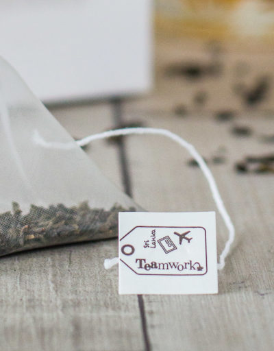 Hoe maak je een theezakje zo duurzaam mogelijk, zonder in te boeten op de kwaliteit van losse thee? Voor dat laatste heb je een piramidezakje nodig: daarin hebben de grote, met de hand geplukte theeblaadjes van TEAmwork Tea de ruimte om te wellen. Ook kun je in piramidezakjes goed zien dat het om echte theeblaadjes gaat. In ondoorzichtige ‘basic’ theezakjes zit vaak gruis van lage kwaliteit. Het komt de fabrikant goed uit dat je er vaak niet echt doorheen kunt kijken, zodat niemand precies ziet wat er nou eigenlijk in dat theezakje zit. Maar van welk materiaal moeten die piramidezakjes dan gemaakt worden, om zo duurzaam mogelijk te zijn? De oplossing: soilon Daarvoor is een materiaal nodig dat volledig biologisch afbreekbaar is. Dan kan het theezakje namelijk op de composthoop en breekt het volledig af, zodat er geen microplastics in het milieu terechtkomen. Mijn TEAmwork Tea contactpersonen in Sri Lanka kwamen met het materiaal SOILON op de proppen. Dit is een bioplastic, gemaakt van een melkzuureiwit, wat weer uit o.a. maiszetmeel gehaald wordt. Het is volledig biologisch afbreekbaar is en mag dus op de composthoop, waar het materiaal binnen een maand volledig ‘verdwenen’ is: omgezet naar CO2 en water. Bovendien kun je zowel het touwtje als het theelabel van het theezakje van dit materiaal maken. Dat klinkt goed, toch? Kwaliteit van de thee? First things first: Het belangrijkste is natuurlijk dat de smaak van de thee goed naar voren komt. Alle andere piramidezakjes worden gemaakt van nylon (puur plastic), omdat dit de beste resultaten geeft qua smaak. SOILON is speciaal ontworpen om een duurzaam alternatief voor nylon theezakjes te bieden. Het lijkt qua kenmerken dus precies op nylon - maar dan biologisch afbreekbaar. Je merkt zelf als theedrinker dus geen verschil tussen een plastic nylonzakje en een biologisch afbreekbaar SOILON piramidezakje. De laatste kun je alleen op de composthoop gooien, waar micro-organismen het afbreken zodat er geen microplastics in de natuur terechtkomen. Test het zelf Mocht je je afvragen of de theezakjes die jij thuis in de kast hebt staan biologisch afbreekbaar zijn, dan is daar een makkelijk (en leuk!) testje voor. Over het algemeen geldt: materiaal dat biologisch afbreekbaar is, brandt. Wil je testen of iets van afbreekbaar materiaal is, dan kun je het dus in de fik steken. Zoals je theezakje! Wie durft? 😉 -x- Claartje Founder TEAmwork Tea